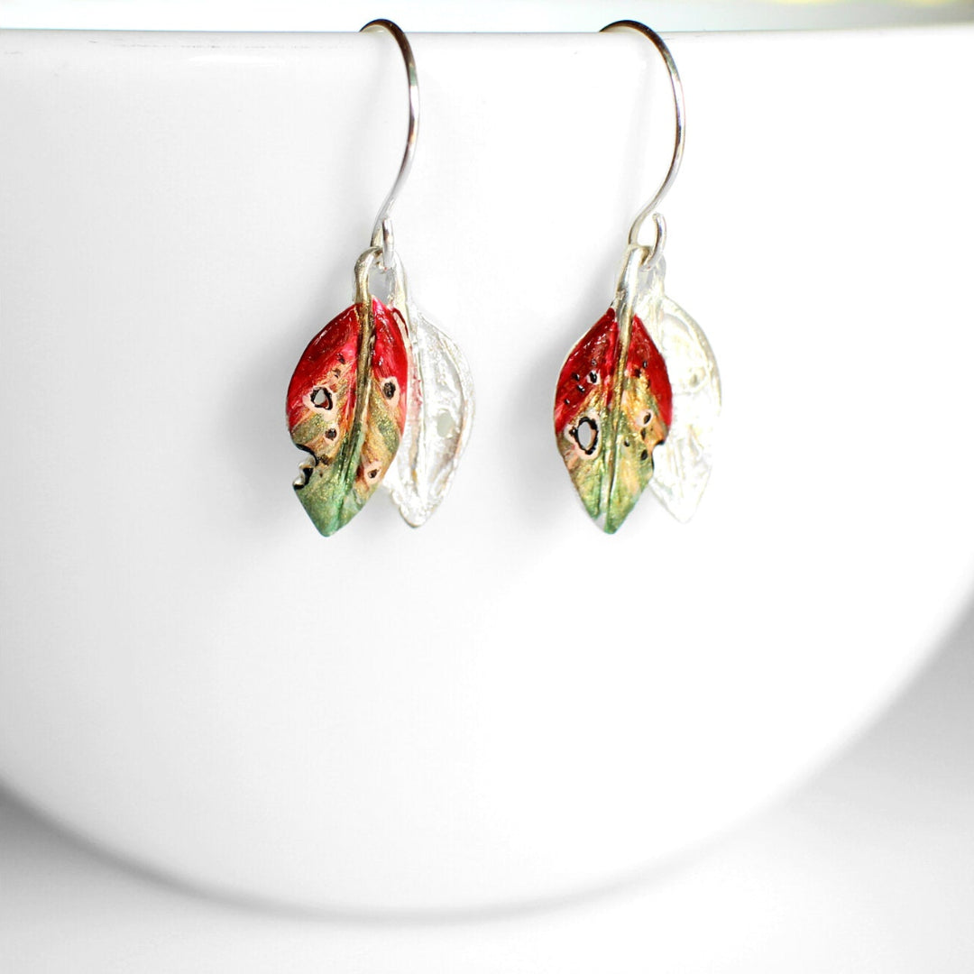 Pair of earrings with colorful leaf-like designs on a white background